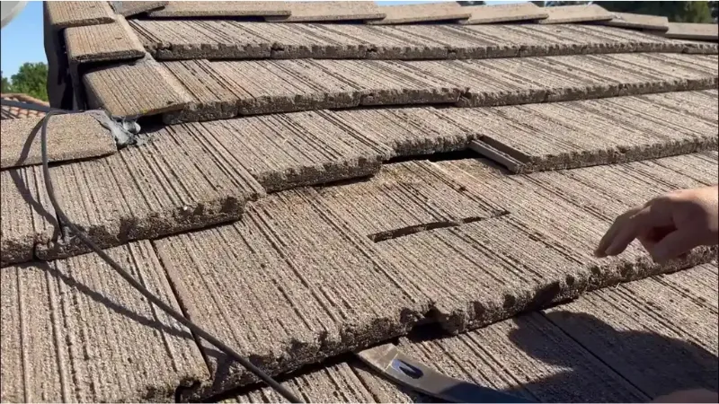 Broken and displaced concrete roof tiles showing an area that needs tile roof repair eugene.