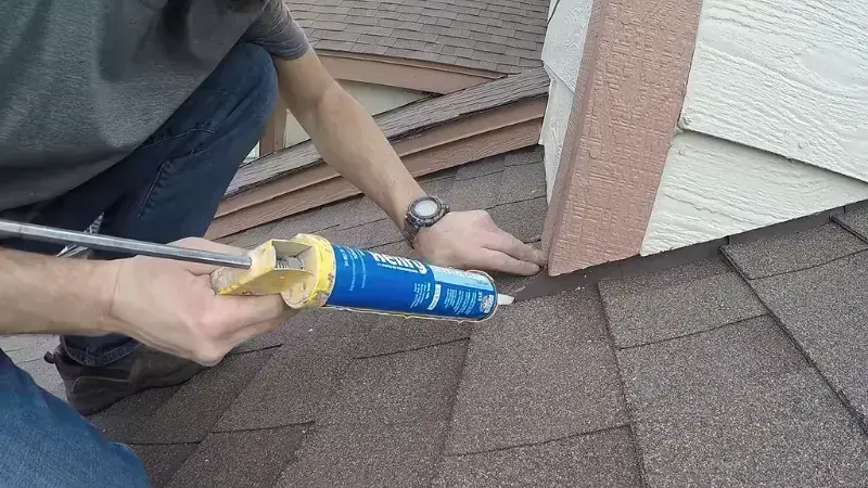 Roof leak repair around a roof-to-wall connection using roofing sealant in Anaheim.