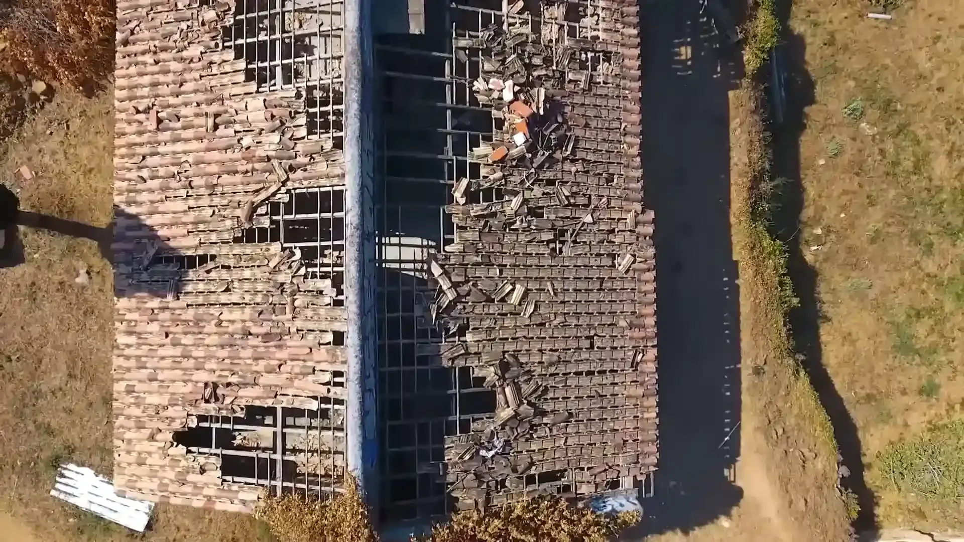 Aerial view of extensive damaged and displaced roof tiles after severe roof damage.